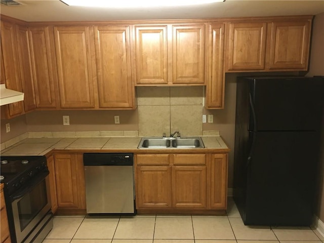 kitchen with sink, decorative backsplash, black appliances, exhaust hood, and light tile patterned floors