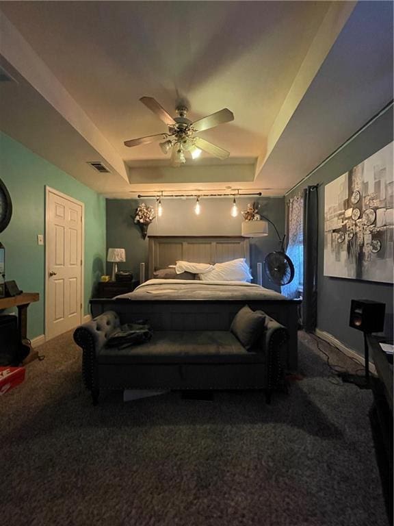 bedroom featuring ceiling fan, a raised ceiling, and carpet flooring