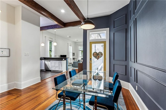 dining area with beam ceiling and dark hardwood / wood-style floors