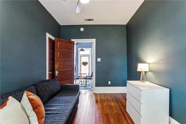 living room featuring ceiling fan and dark wood-type flooring