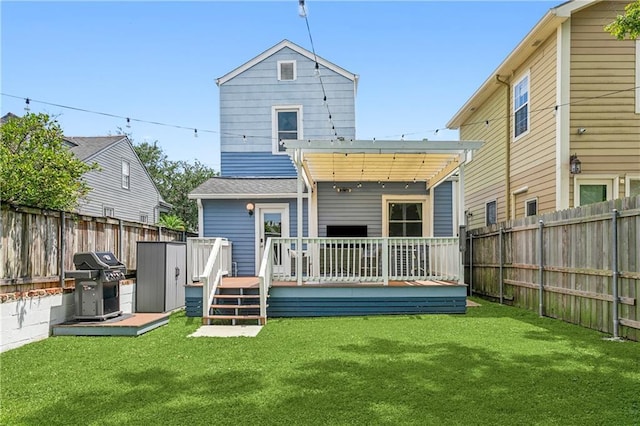 back of house featuring a lawn, a pergola, a shed, and a deck