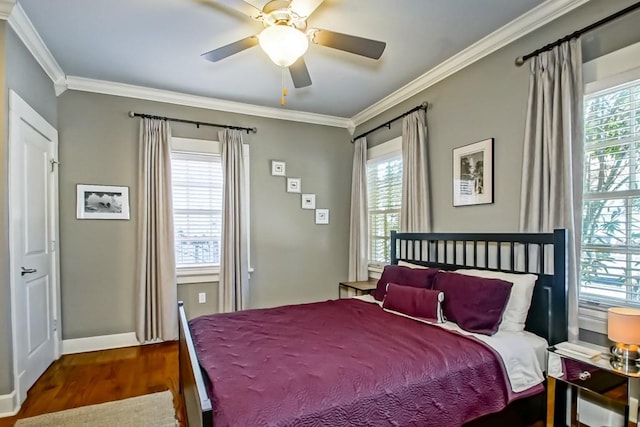 bedroom with ceiling fan, crown molding, wood-type flooring, and multiple windows