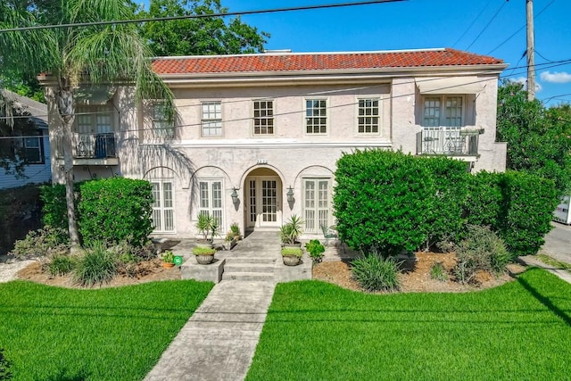 mediterranean / spanish-style home with a balcony and a front yard