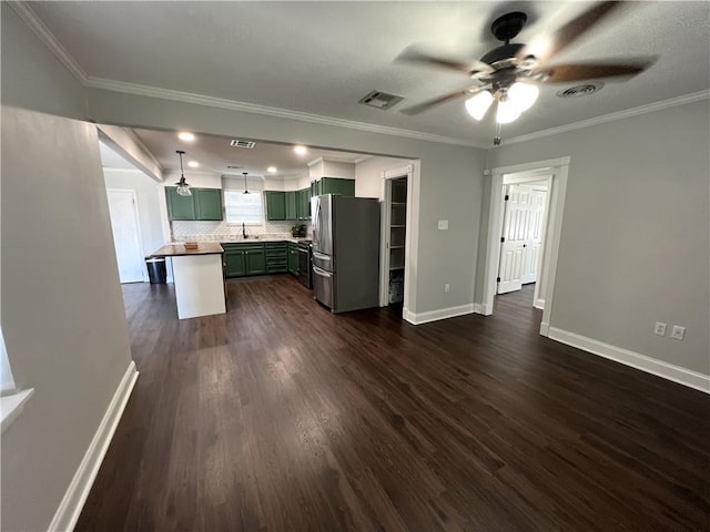 kitchen featuring backsplash, dark hardwood / wood-style floors, stainless steel refrigerator, ceiling fan, and crown molding