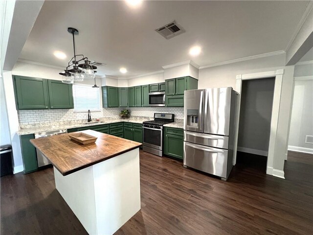 kitchen featuring dark hardwood / wood-style floors, crown molding, stainless steel appliances, and tasteful backsplash