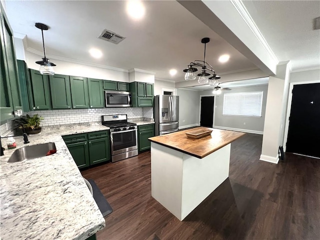 kitchen featuring sink, wood counters, appliances with stainless steel finishes, dark hardwood / wood-style floors, and tasteful backsplash