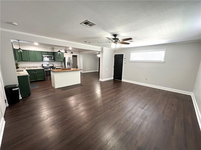 unfurnished living room featuring ceiling fan, ornamental molding, a textured ceiling, and dark hardwood / wood-style flooring