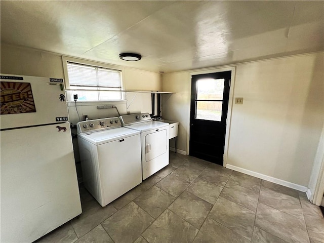 washroom with a wealth of natural light, sink, separate washer and dryer, and light tile patterned floors