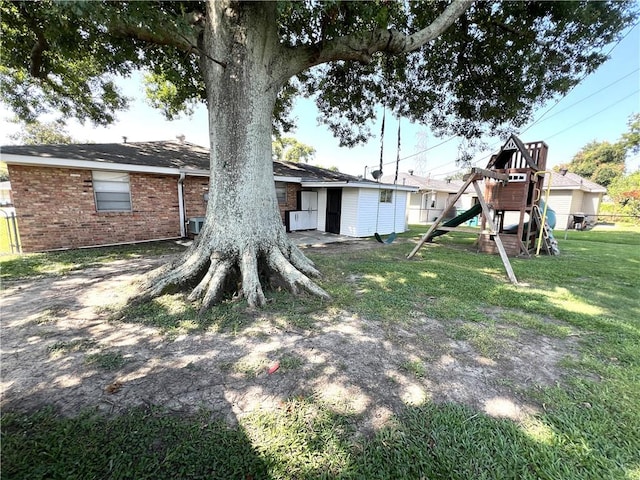 rear view of property with a lawn and a playground