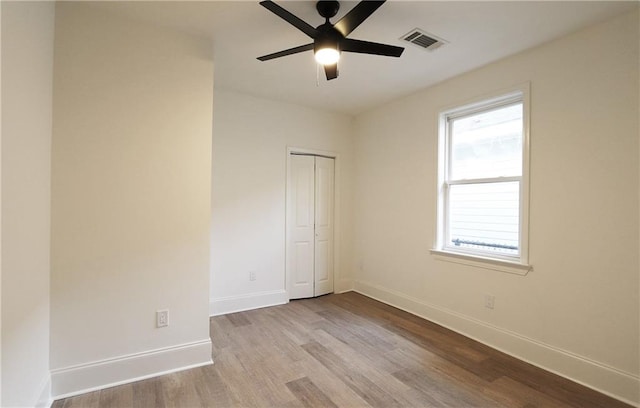 empty room with ceiling fan and light hardwood / wood-style floors