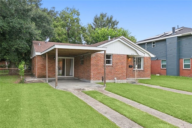 rear view of property featuring brick siding, a yard, and fence