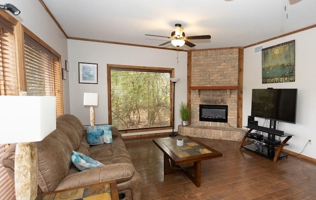 living room with ceiling fan, dark wood-type flooring, brick wall, a fireplace, and crown molding