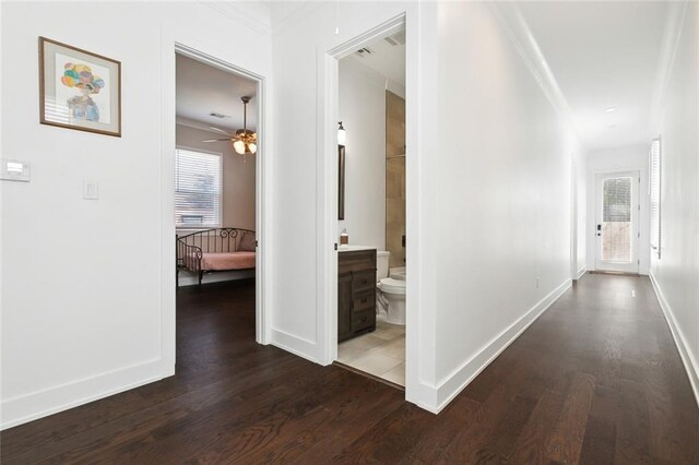 hallway with ornamental molding and hardwood / wood-style flooring