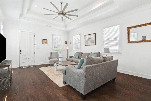 living room featuring ceiling fan, a raised ceiling, crown molding, and dark hardwood / wood-style floors