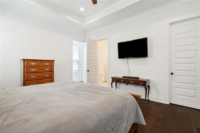 bedroom featuring connected bathroom, a raised ceiling, dark wood-type flooring, and ceiling fan