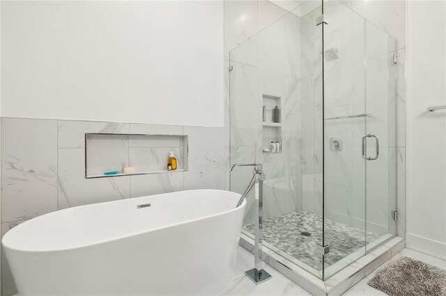 bathroom featuring tile walls, independent shower and bath, and tile patterned floors