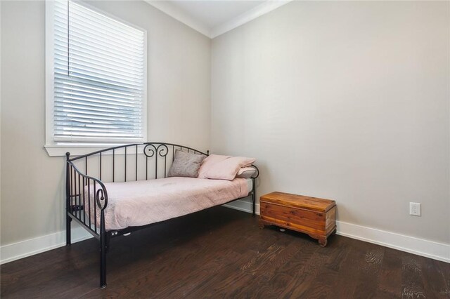 bedroom featuring multiple windows, ornamental molding, and wood-type flooring