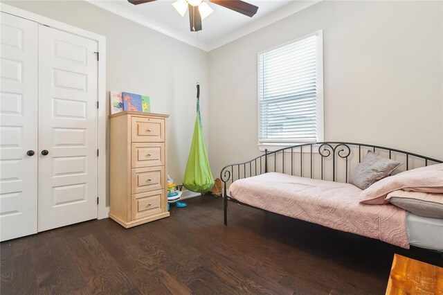 bedroom featuring ceiling fan, a closet, hardwood / wood-style flooring, and ornamental molding