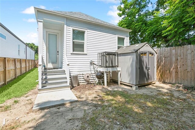 rear view of house with a storage shed