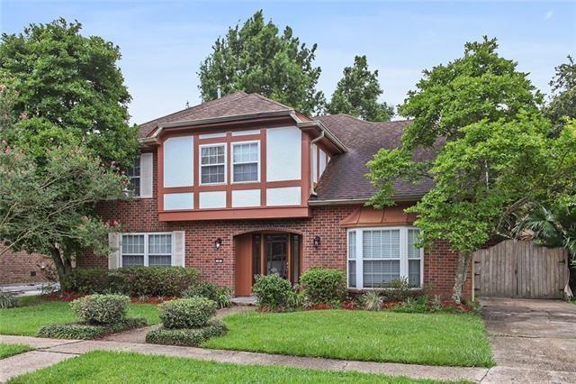 5 Kings Canyon Dr, New Orleans, LA 70131 - tudor house with brick siding, stucco siding, a front lawn, and a gate