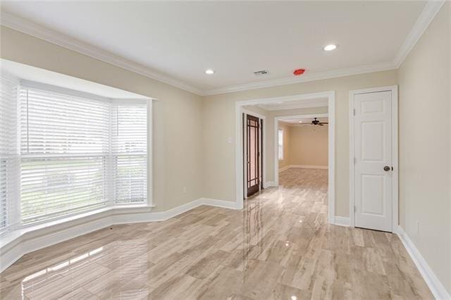 spare room with light wood-type flooring, ceiling fan, and crown molding