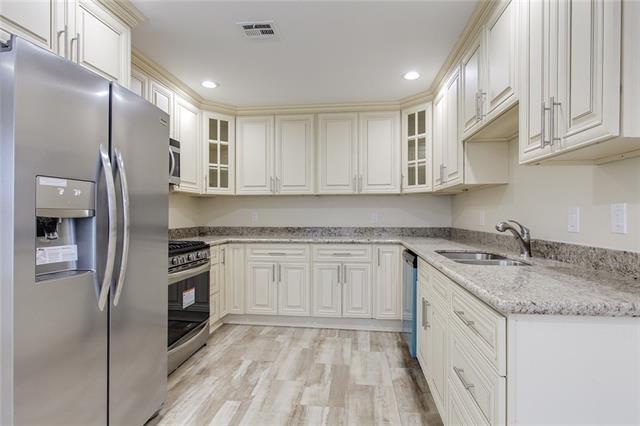 5 Kings Canyon Dr, New Orleans, LA 70131 - kitchen with light wood finished floors, visible vents, glass insert cabinets, appliances with stainless steel finishes, and a sink