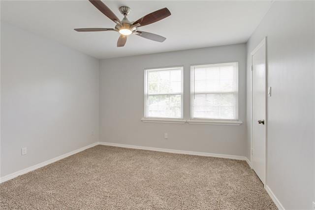 carpeted spare room with ceiling fan