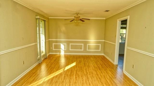 unfurnished room with baseboards, wood finished floors, a ceiling fan, and crown molding