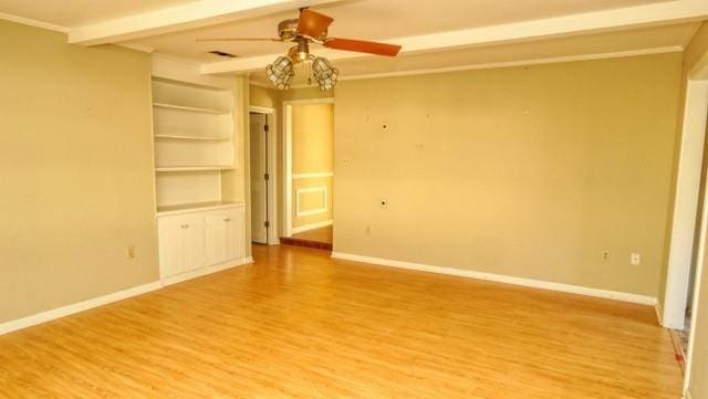 spare room featuring ceiling fan, beamed ceiling, light wood-type flooring, and baseboards