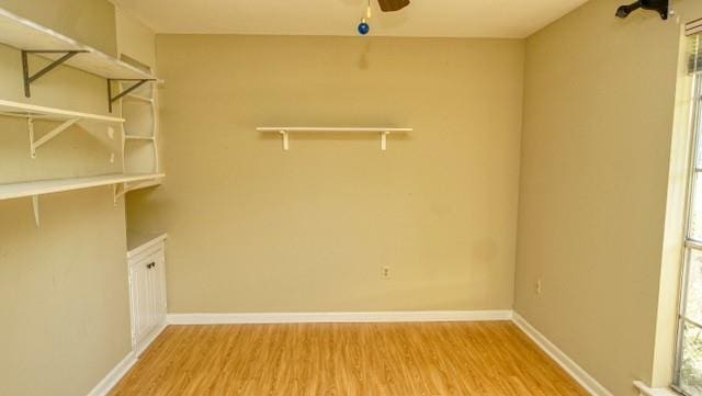 laundry area featuring a ceiling fan, baseboards, and wood finished floors