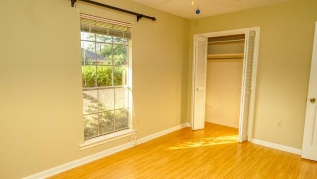 unfurnished bedroom with baseboards and wood finished floors