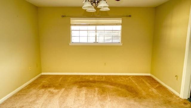 carpeted empty room featuring baseboards