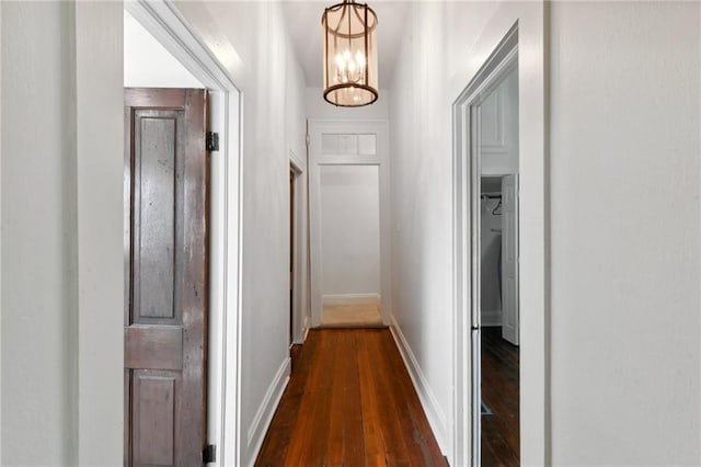 hallway featuring dark hardwood / wood-style floors and a notable chandelier