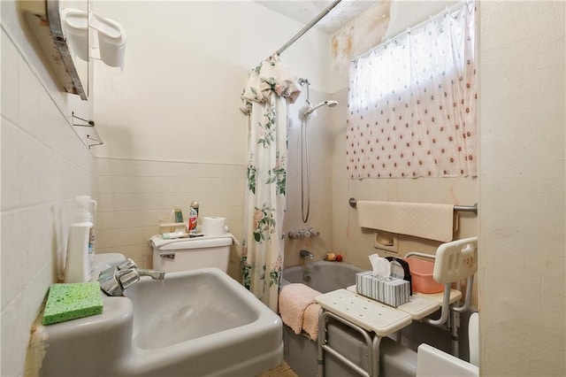 full bathroom featuring sink, toilet, shower / tub combo with curtain, and tile walls