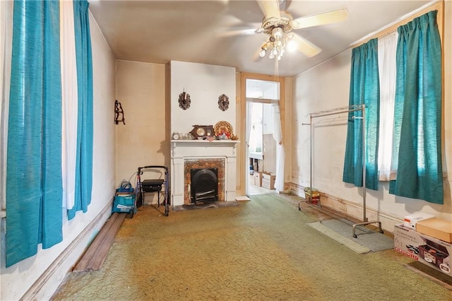 unfurnished living room with ceiling fan and carpet flooring