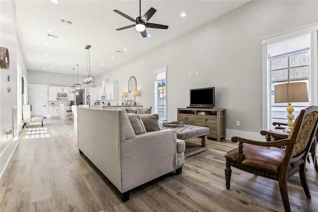 living room featuring ceiling fan and light hardwood / wood-style flooring