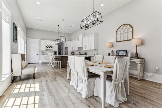 dining space featuring light hardwood / wood-style flooring and a notable chandelier