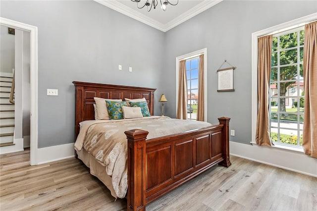 bedroom with light wood-type flooring, an inviting chandelier, and ornamental molding