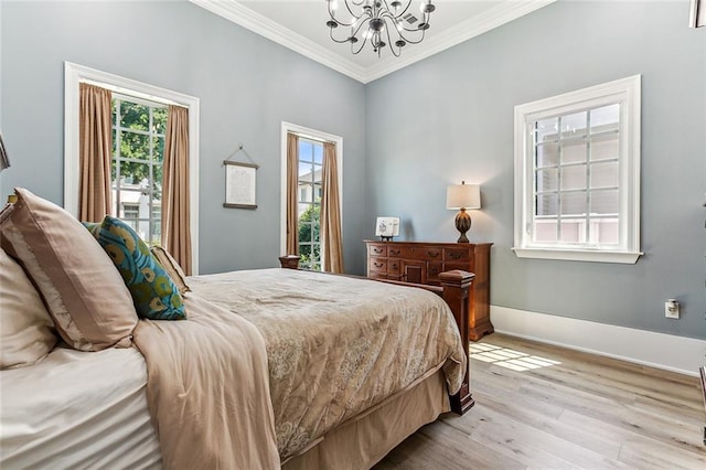 bedroom featuring light hardwood / wood-style floors, ornamental molding, and a chandelier