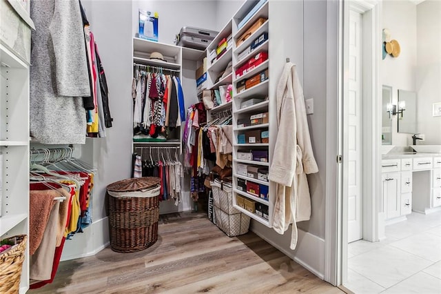 walk in closet with light tile patterned floors and sink