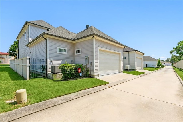 exterior space featuring a garage, central air condition unit, and a front yard