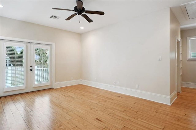 unfurnished room with visible vents, baseboards, french doors, light wood-type flooring, and attic access