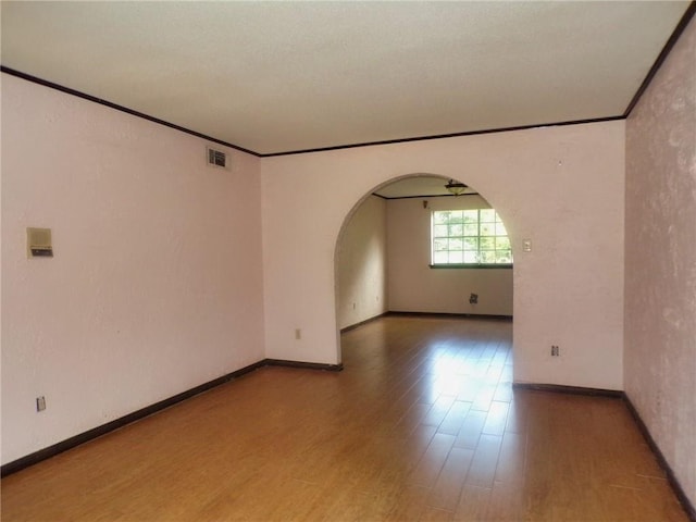 spare room featuring hardwood / wood-style flooring and crown molding