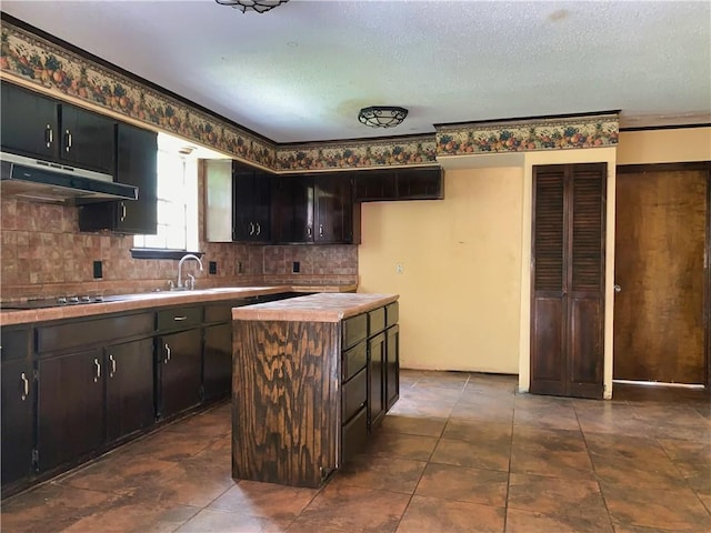 kitchen featuring sink, black electric stovetop, decorative backsplash, and dark tile patterned floors