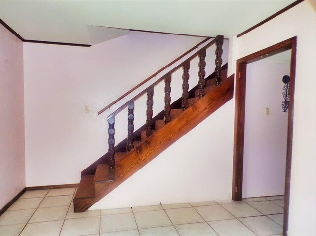 staircase with tile patterned flooring and crown molding