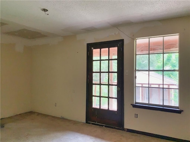 doorway to outside with a textured ceiling