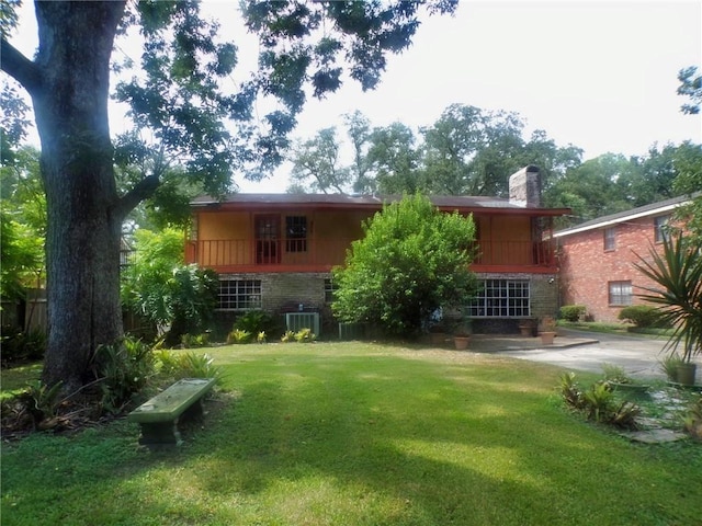 back of house featuring central AC unit and a yard