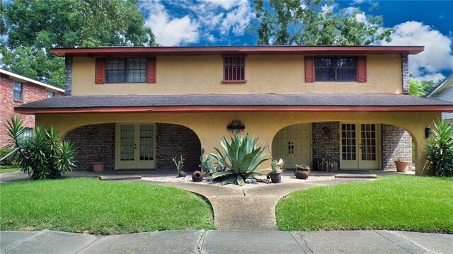 view of front of house featuring a front yard and french doors