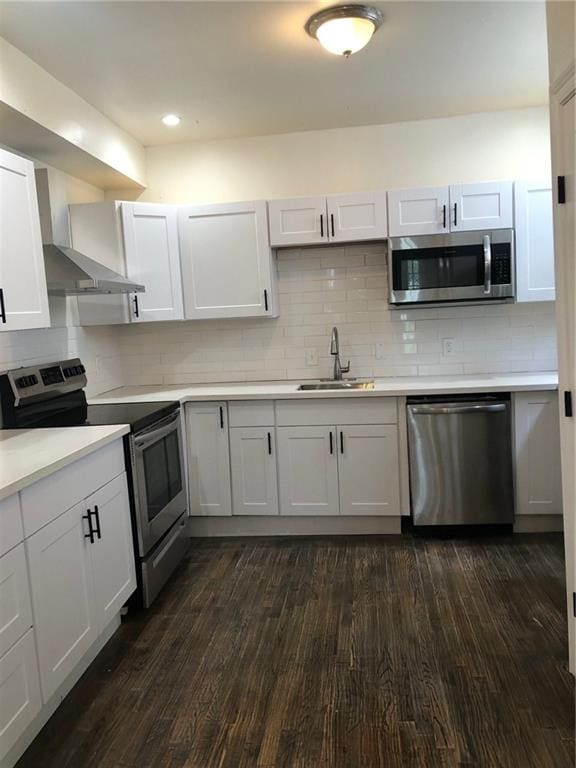 kitchen featuring stainless steel appliances, white cabinetry, tasteful backsplash, sink, and dark hardwood / wood-style flooring