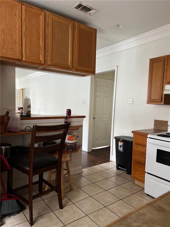 kitchen featuring white range with electric cooktop, light hardwood / wood-style floors, and ornamental molding